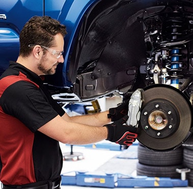  Toyota Technician working on brakes